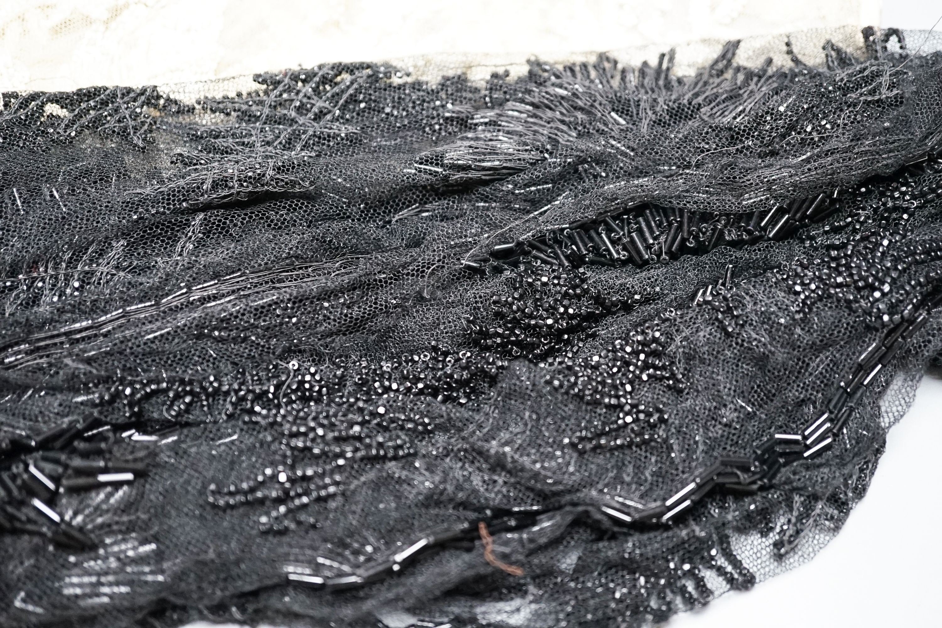 A collection of Edwardian and later sequin and beaded panels on net, a black beaded stole, various buttons etc.